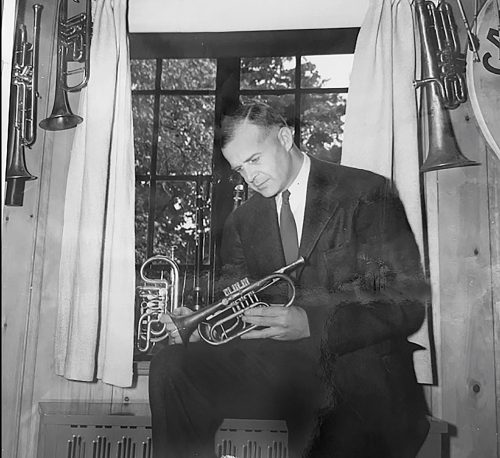 a black and white photograph of Ralph Gould holding a trumpet